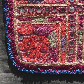 Embroidered and beaded panel, probably Pashtun from Afghanistan, fine ladder stitching and gold metal threads with mirror discs, blue beads around, 24.5 cm square, probably mid-20th century, mounted on black canvas  