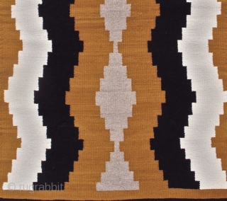 This simple small vintage mid 20th century Navajo rug paints waves of natural ivory and brown to form subtle intimations of side-borders. A column of grey diamonds is drawn along the center  ...