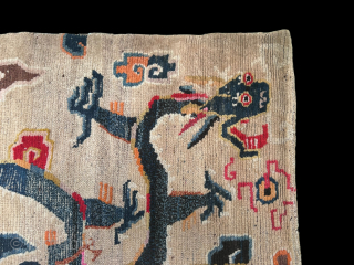 A white groung Tibetan Dragon mat. The Dragon chasing a flaming pearl and surrounded by clouds. 19th century.               