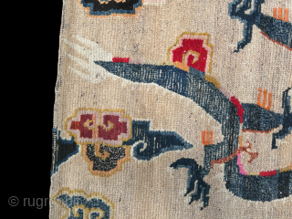 A white groung Tibetan Dragon mat. The Dragon chasing a flaming pearl and surrounded by clouds. 19th century.               