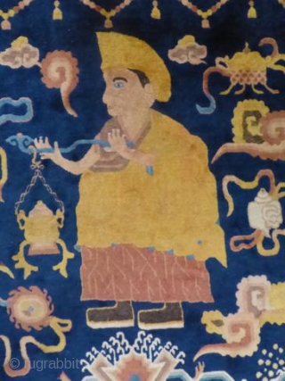 Ningxia  Temple Banner Rug, The indigo field depicting a Lama with censor surrounded by Buddhist motifs, 180cm by 121cm             