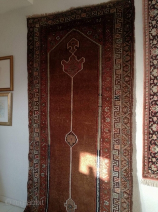 An antique camel hair ground NW Persian runner with 430/108 cm in good condition. Two spots repiled. One side with kilim ending, the other open. On wool rug.     