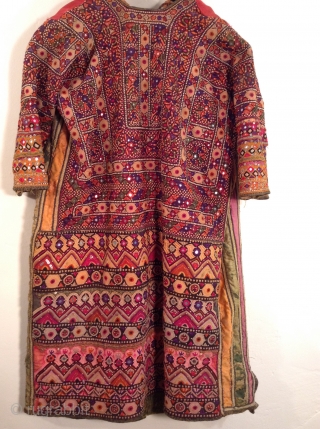 This is a wonderful embroidered dress from Rajasthan, India.  The embroidery covers all of the fabric except for the neckline and several strips of Satin fabric under the arms.  Some  ...