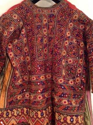 This is a wonderful embroidered dress from Rajasthan, India.  The embroidery covers all of the fabric except for the neckline and several strips of Satin fabric under the arms.  Some  ...