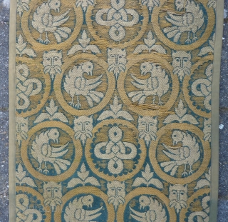 A long and narrow textile panel, 264  x 73 cm., 8’7” x 2’5”, with a repeat of circular medallions enclosing birds or endless knots is interspersed with satyr’s masks and leaves  ...