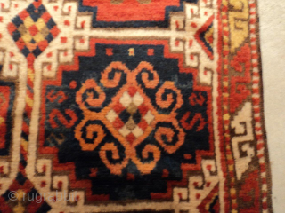 This circa 1875 Caucasian Kazak rug measures 3’9” X 6’6”. It has the Mogan motif in red and blue with ivory negative spaces. It has one narrow border with the lazy S  ...
