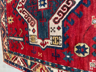 This third quarter 19th century Facralo Kazak antique Caucasian Oriental rug measures 4’3” X 4’9”. It has a six pointed star center medallion in red, ivory, and blue on a tomato red  ...