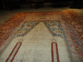 This 3rd quarter 19th century Angora Oushak Oriental Rug #8119 measures 6’7” X 11’6”. The prayer design is in ivory containing two columns in rust with a bulbous design at either end  ...