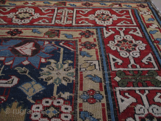 This pre 1850 Kuba measures 3’7” X 9’4”. It has a dark blue ground with a very interesting motif. There are 22 blossoms in shades of green, red, blue, and tobacco completely  ...
