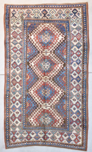 This third quarter 19th century Kazak Oriental Rug #8149 measures 4’1” X 6’9”. It has 3 ½ diamond shaped medallions running up the field surrounded with latchhook borders in ivory. The center  ...