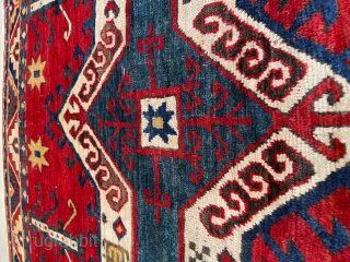 This third quarter 19th century Facralo Kazak #8102 antique Caucasian Oriental rug measures 4’3” x 4’9”. It has a six pointed star center medallion in red, ivory, and blue on a tomato  ...