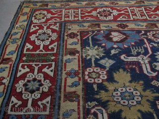 This pre 1850 Kuba measures 3’7” X 9’4”. It has a dark blue ground with a very interesting motif. There are 22 blossoms in shades of green, red, blue, and tobacco completely  ...