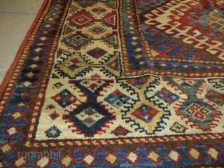 This third quarter 19th century Kazak measures 4’1” X 6’9”. It has 3 ½ diamond shaped medallions running up the field surrounded with latchhook borders in ivory. The center motif flows inward  ...