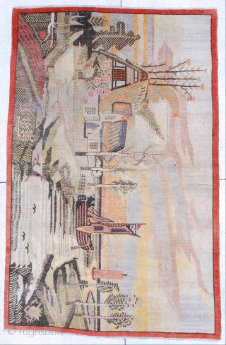 This circa 1920 antique Khotan rug #6795 measures 5 ‘10” x 9’ 0 “. It has a fantastically drawn scene of a house on the water with a lovely tiled roof sitting  ...