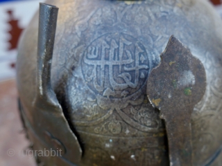 An antique Indo-Persian Helmet (Khula Khud) 19 th. century, Quajar. The front with nose shield and plume holders. Finely engraved with seated mediators and Islamic Galligraphy. length: 40 cm (with chain) diameter  ...