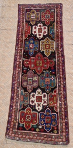 An Artsakh Karabagh long rug,( Nagorno Karabagh)  312 x  102 cm. Late 19th. century. 
 Dark chocolate brown ground with shield design with soft pastel tones: aquamarine, mauve, ocre, sea-green.  ...