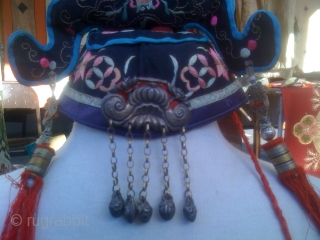 (1) OLD CHINESE HAT OR HEAD COVERING FOR CHILD WEAR FOR GOOD LUCK

Cotton ground with silk floss embroidery. Eight silver metal immortals are sewn on to front, additional metal decoration is attached  ...