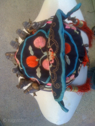 (1) OLD CHINESE HAT OR HEAD COVERING FOR CHILD WEAR FOR GOOD LUCK

Cotton ground with silk floss embroidery. Eight silver metal immortals are sewn on to front, additional metal decoration is attached  ...