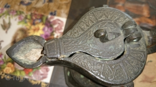 This is a cast bronze oil lamp from the Seljuq era in Khorassan, N.E. of Iran, ca. 12th century A.D. There is an inscription around the lid that I can not decipher.  ...