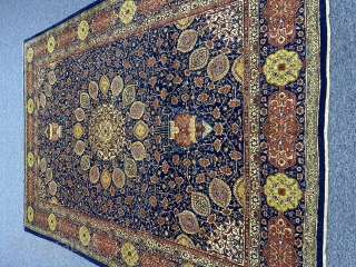 A Tabriz carpet with an 'Ardabil Carpet' medallion design, set against a blue foundation and complemented by red and yellow patterns on blue borders, often represents a beautiful and intricate piece of  ...