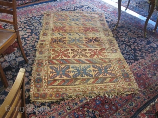 kurdish carpet, worn due to age, set on linen                        