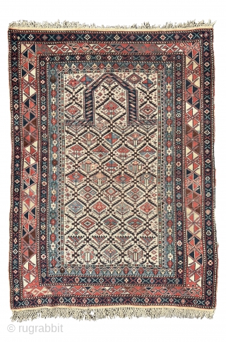 Shirvan prayer rug
This East Caucasian prayer rug shows a characteristic diamond lattice design of dark blue serrated leaves enclosing flowering shrubs in its white field containing the bridge-shaped prayer arch at the  ...