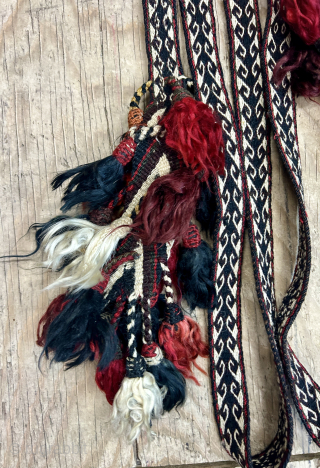 An impressive antique Qashqai narrow tent band. It seems to be for tying loads on camels and horses. The pom-poms at each end add so much charm to the piece and suggest  ...