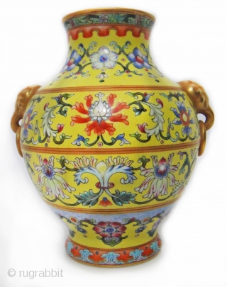 An important and very rare yellow-ground famille rose vase. iron-blue six-character sealmark and of the period (1796-1820)The vase of compressed pear-shape, elaborately decorated with four large blossoming lotus evenly spaced around the  ...