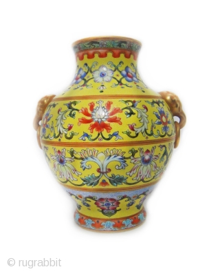 An important and very rare yellow-ground famille rose vase. iron-blue six-character sealmark and of the period (1796-1820)The vase of compressed pear-shape, elaborately decorated with four large blossoming lotus evenly spaced around the  ...