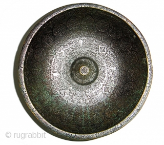 A PERSIAN / MUGHAL BRONZE MAGIC BOWL 

of deep rounded form supported on a raised foot, with narrow everted rim and raised omphalos with attached circular tray with pierced rim, the interior  ...