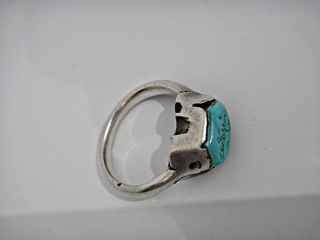 A Seljuk turquoise-set Silver Ring. Persia, 12th-13th Century. 

the bazel engraved with arabesques kufic words engraved name .

Condition Report : Extremly fine cleaned          
