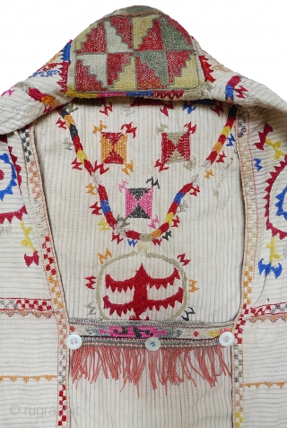 Woman's Jelak. South Uzbekistan, second quarter 20th century. Silk hand-embroidery on handwoven cotton with narrow stripes. Unlined. Silk woven and embroidered trim applied along edge; silk fringe; three pearl buttons. 35" length  ...