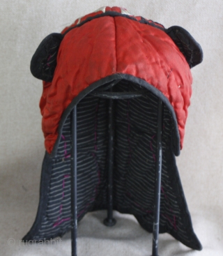 EMT156   This old Chinese Miao ethnic minority child's hat is thickly padded for winter wearing. The red silk fabric with silk thread satin stitch embroidery really stands out. One silver  ...