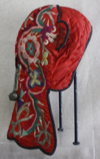 EMT156   This old Chinese Miao ethnic minority child's hat is thickly padded for winter wearing. The red silk fabric with silk thread satin stitch embroidery really stands out. One silver  ...