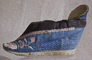 TC 388  This antique Chinese pair of lotus embroidered lotus shoes are most likely from northern china. the vamp is a quilted cotton fabric. Each shoe is embroidered with the same  ...