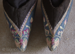 TC 388  This antique Chinese pair of lotus embroidered lotus shoes are most likely from northern china. the vamp is a quilted cotton fabric. Each shoe is embroidered with the same  ...