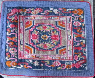 Tibetan Sitting Mat 1900 -1920
Heavy thick wool hand made/
home made-not for the tourist trade.
Wool cloth on the front and blue cotton on the back
quilted. Mixed dyes. Good for meditation.    
