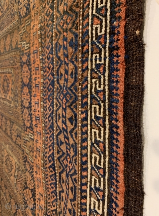 Antique Maadan Baluch Long Rug. Northeast Persia, Khorasan. This finely woven brown field offers a captivating inner border of rams. The central tribal design patterns are seen enclosed by 9 intricate borders.  ...