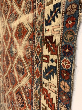 Antique Caucasian Small Rug. Circa Early. Two columns of ivory diamond lattice with alternating rows of gols. Leaf and wine glass border. Remnants of embroidered macrame ends on top. Original condition with  ...