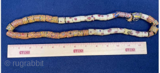 Millefiori African Trade Beads Necklace. Intricately designed mosaic-pattern glass beaded necklace with vibrant patterns. Age circa 1900.  Nearly 50 beads make up this necklace! 

These mosaic glass beads were used as  ...
