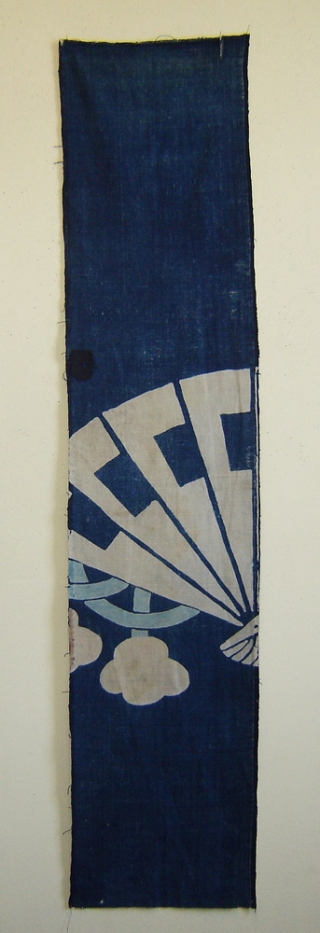 Tsutsugaki futonji panel, Japan, Meiji (circa 1880), cm 149x33. This is a panel from a bedding cloth (futonji) decorated in the so-called ‘tsutsugaki’ technique, with the pattern of a fan in white  ...