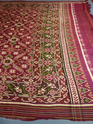 Early nineteenth century

India

Sumptuous red double silk woven shawl called Patola from India. Repetition of geometric patterns (hearts, flowers and stars) in cream, green and ocher drawing lozenges.
Borders of stripes and geometric friezes.  ...