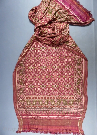 Early nineteenth century

India

Sumptuous red double silk woven shawl called Patola from India. Repetition of geometric patterns (hearts, flowers and stars) in cream, green and ocher drawing lozenges.
Borders of stripes and geometric friezes.  ...