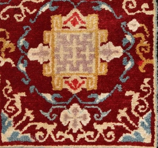 Striking Tibetan makden (‘under-saddle’ carpet) exhibiting a Khotan-like influence with an elaborate mandala motif surrounded by a fine trellis-like circular blue ‘necklace'. The main rose coloured outer border consist of alternating floral  ...