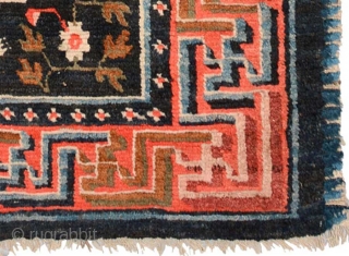 Strikingly vibrant Tibetan khaden with three medallions and the so-called 'frog foot' design scattered throughout the center field. The main border is a well executed interlocking yungdrung (swastika) design with an almost  ...