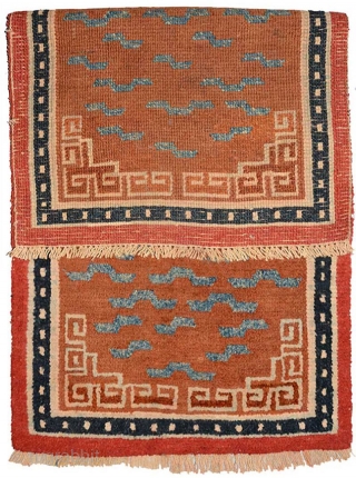 Tibetan carpet of an irregular size with a 'stylised' tiger striped center field design that may have been used as a dais / bench cover or for seating, or may have been  ...