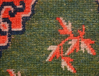Thick piled natural dyed Tibetan khaden with a central mandala-like motif with leaves spread sparingly about in a lovely marled green main field, which itself has a wonderful abrash. The four corners  ...