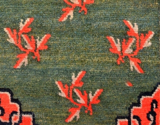 Thick piled natural dyed Tibetan khaden with a central mandala-like motif with leaves spread sparingly about in a lovely marled green main field, which itself has a wonderful abrash. The four corners  ...