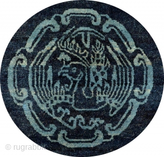 Two-toned naturally dyed Tibetan seating carpet – or shugden - with light blue coloured motifs of various sorts over a darker blue background. The outer border consist of assorted esoteric symbols while  ...