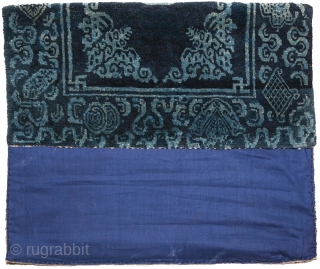 Two-toned naturally dyed Tibetan seating carpet – or shugden - with light blue coloured motifs of various sorts over a darker blue background. The outer border consist of assorted esoteric symbols while  ...